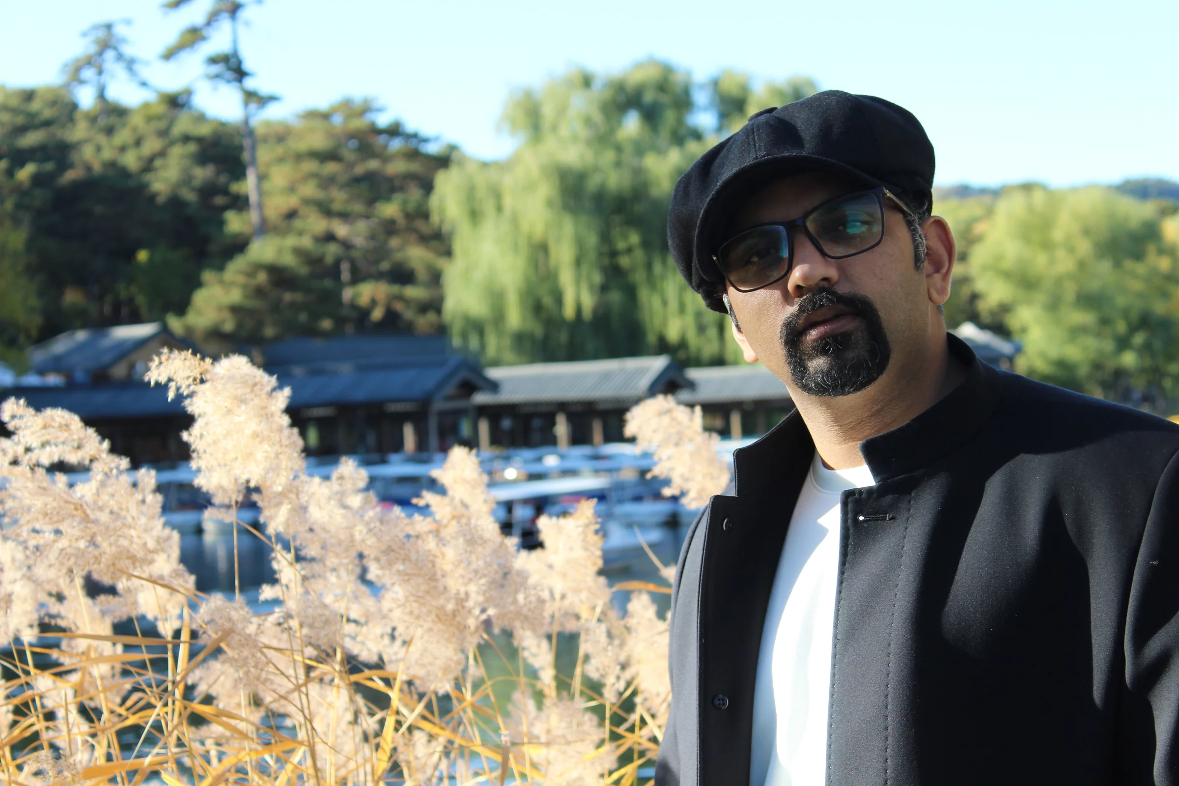 Muhammad Awais wearing a black cap, glasses and jacket outdoors